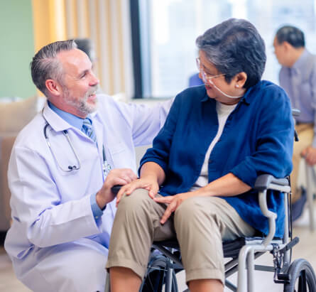 Senior patient in a wheelchair talks to their doctor