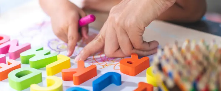Little girl is learning English letters.